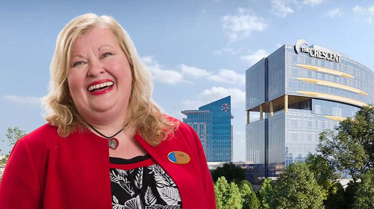 Turning Stone team member smiling in a red cardigan in front of the Crescent